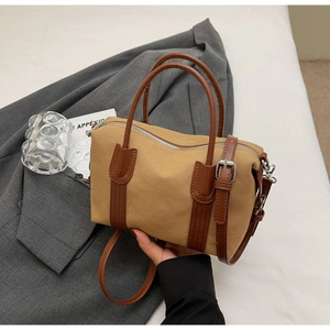 Détail du sac Boston en toile vintage avec poignées en cuir marron et bandoulière