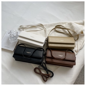 Flat lay of vintage baguette bags in white, beige, black and coffee colors on a soft background