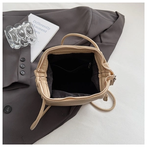 Detailed interior of the beige lychee pattern leather crossbody bag with zipper pocket