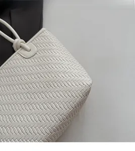 Détail de la texture tressée blanche et du nœud sur ce sac à bandoulière chic