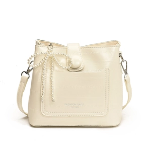 Creamy white minimalist bucket bag with pearl bow charm and textured finish