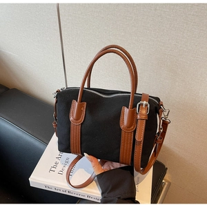 Détail du sac Boston en toile avec anses en cuir marron et fermeture éclair argent