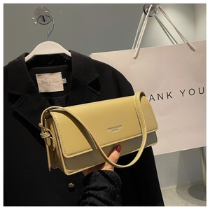 Detail of avocado green leather baguette bag with 'FASHION & BAGS' embossed logo
