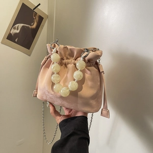 Chic beaded handle drawstring bucket bag in soft pink fabric with silver chain strap