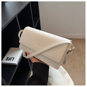 Detail of cream rectangle flap shoulder bag featuring elegant diagonal stitching and leather texture