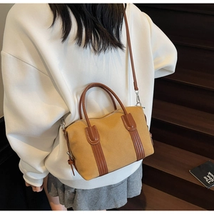 Sac Boston rétro en toile avec poignées en cuir et bandoulière porté par mannequin