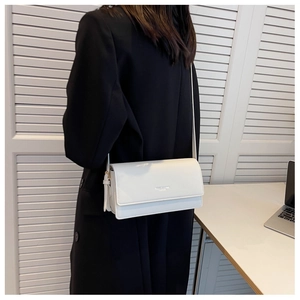 Detail view of the white leather shoulder bag showing the smooth texture and brand logo