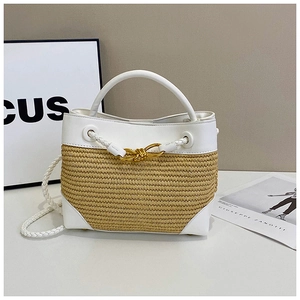 Detail of summer woven tote with white leather trim and gold decorative knot buckle