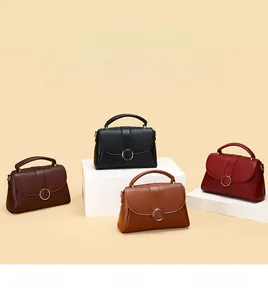 Detail of four cowhide leather handbags in brown, black, caramel and red with metal rings