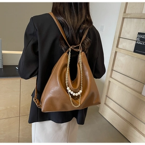 Detail of brown PU tote bag with chunky gold chain and large pearl accents on back
