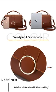 Macro detail of brown leather shoulder bag featuring reinforced stitching and metal buckle