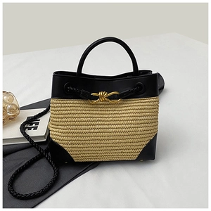 Detail of woven straw texture with black leather trim and gold metal twist-lock buckle