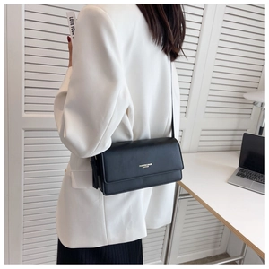 Classic black leather shoulder bag with gold lettering shown in office setting