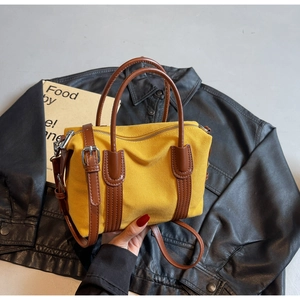 Détail du sac Boston en toile jaune avec bordure en cuir marron et zip métallique