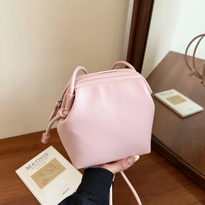 Minimalist pink faux leather crossbody square bag with a textured finish and shoulder strap