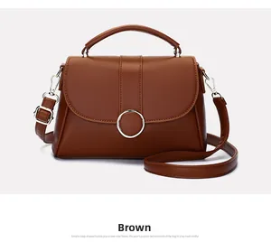 Macro view of brown leather handbag with luxury gold buckle and texture detail