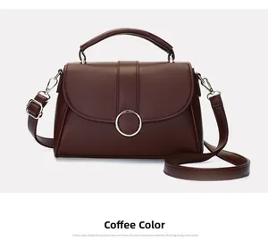 Detail of dark coffee leather handbag featuring a circular metal buckle and adjustable strap