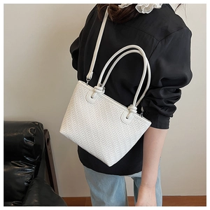 Détail du sac en cuir tressé blanc avec poignée élégante et design de bandoulière réglable