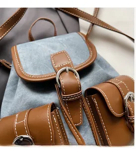 Detail of denim and brown leather patchwork with contrast stitching and silver buckle