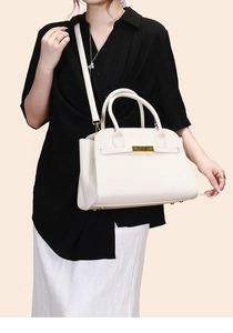 Close-up of white lychee-patterned leather tote with golden hardware and metal rivets