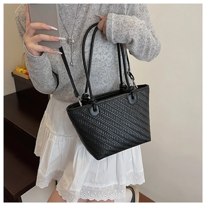 Détail du sac bandoulière noir avec texture tressée en V et fines bretelles élégantes
