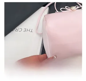 Detailansicht der Präzisionsnähte an einer rosa Ledertasche mit Perlen und Schleife