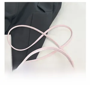 Detailaufnahme der rosa Ledertasche mit schicker rechteckiger Schnalle und dünnen Riemen
