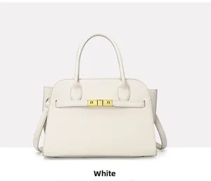 Detail of white litchi pattern tote bag with gold metal lock and dual top handles