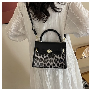 Dettaglio della borsa leopardata alla moda con fibbia dorata e tracolla su modella