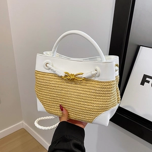 Handwoven straw bucket bag with white leather trim and golden twist-lock buckle