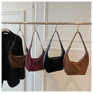 Gros plan de quatre sacs hobo en daim minimalistes en marron, bordeaux, noir et caramel