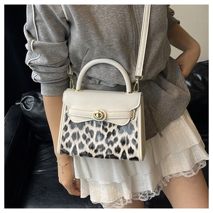 Dettaglio mini borsa bianca con pannello leopardato e chiusura dorata su modello