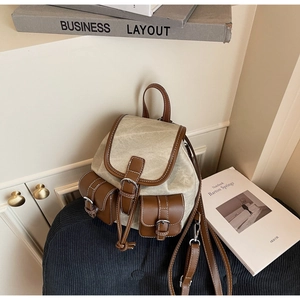 Detail of vintage canvas backpack with brown leather trim and two front flap pockets