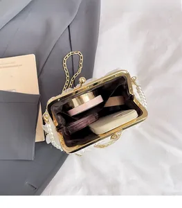 Detail of white lace handbag showing interior space for phone and makeup with pearl trim