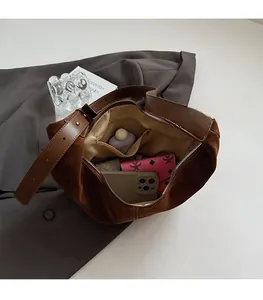 Vue intérieure du sac hobo en daim marron montrant le compartiment principal spacieux