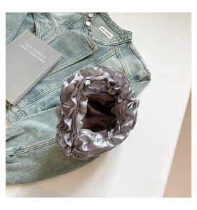 Macro detail of silver pleated ruffle handbag with premium silk texture and top zipper