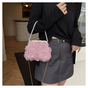 Detail of pink floral handbag with 3D fabric roses, pearl handle and gold clasp