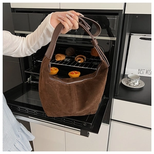 Détail d'un sac hobo en daim marron café foncé avec fermeture éclair et coutures