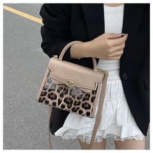 Dettaglio della borsa a tracolla leopardata con patta in pelle beige e fibbia dorata