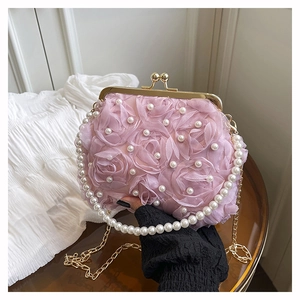 Close-up of pink 3D floral evening bag with pearl accents and gold metal clasp