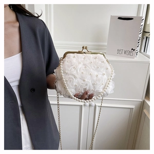 Detail of white 3D floral evening bag with pearl handle and golden vintage clasp