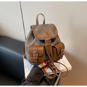 Detail of vintage canvas backpack with brown leather pockets and metal buckle straps