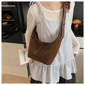 Détail du sac hobo en daim marron foncé au style vintage dans une scène de cuisine cosy