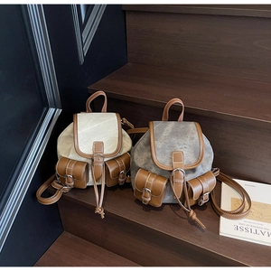 Close-up of vintage canvas and leather buckles on dual-tone retro backpacks