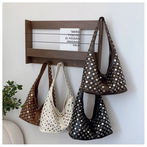 Sacs hobo rétro cloutés en quatre couleurs présentés sur un support en bois