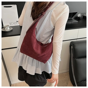 Sac hobo bordeaux en daim mat présenté dans un cadre de bureau professionnel élégant