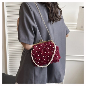 Detail of burgundy satin rose evening bag with elegant pearl strap and metallic closure