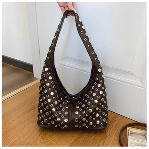 Détail du sac cabas marron foncé orné de clous argentés et d'un style punk tendance