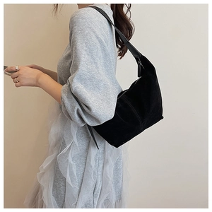 Détail du sac hobo en daim noir avec bandoulière en cuir et fermeture éclair sûre