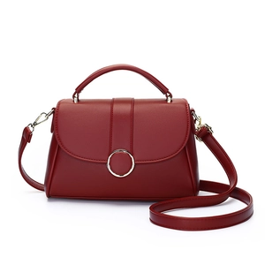 Elegant deep red matte leather handbag with golden ring buckle and adjustable strap